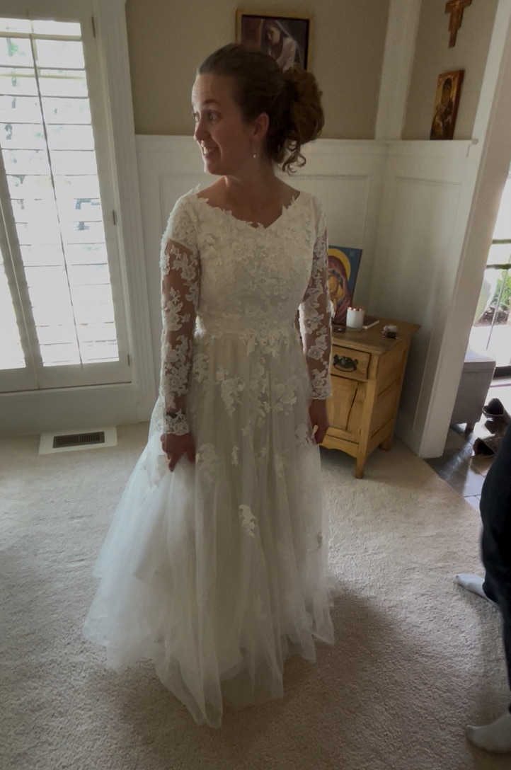 Bride in lace wedding dress at fitting