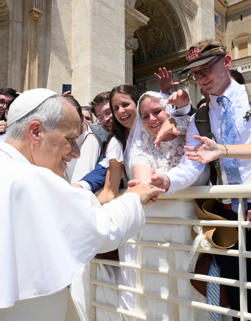 Bride in custom veil and dress greeting the Pope