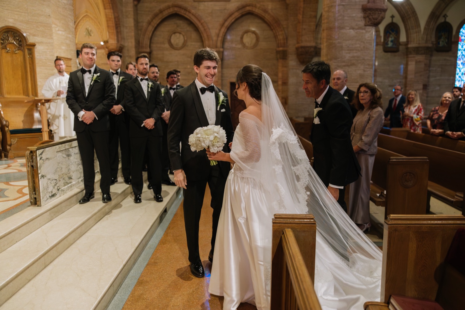 Gabby and groom at the altar with custom cathedral veil