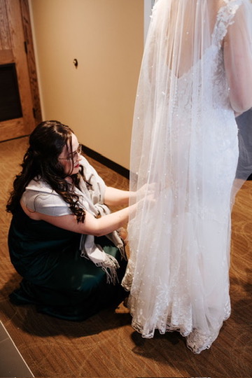 Ione adjusting a bride's train at the venue